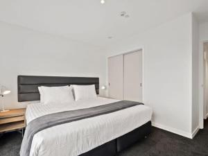 a bedroom with a large bed and a wooden table at Shotover Serenity in Queenstown