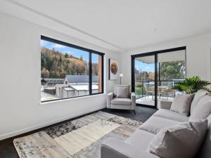 a living room with a couch and a large window at Shotover Serenity in Queenstown