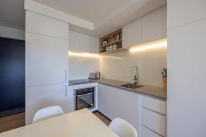 a kitchen with white cabinets and a table and chairs at Rivers Bank in Albert Town