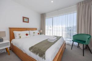 1 dormitorio con 1 cama grande y 1 silla verde en Rivers Bank en Albert Town