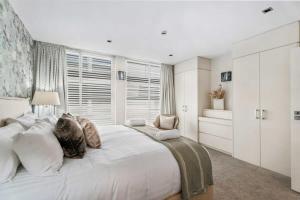 a large white bedroom with a large bed and a window at Pembroke Luxury Apartment in Wanaka