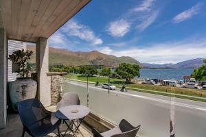 a balcony with chairs and a view of the water at Pembroke Luxury Apartment in Wanaka