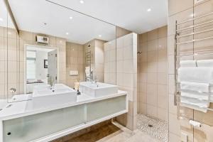 a bathroom with two sinks and a mirror at Pembroke - Luxury 1 Bedroom Apartment in Wanaka