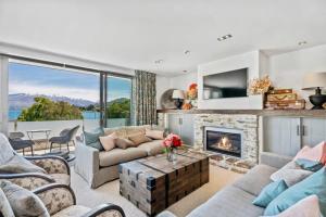 a living room with a couch and a fireplace at Pembroke - Luxury 1 Bedroom Apartment in Wanaka