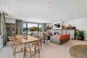 a living room with a couch and a table and chairs at Pembroke - Luxury 1 Bedroom Apartment in Wanaka