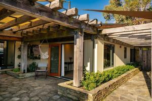 a home with a wooden pergola and a patio at Dublin Downs in Albert Town