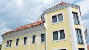 a yellow building with a red roof at Toldi Apartments Pécs in Pécs