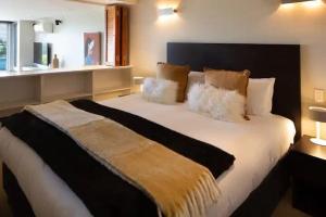 een slaapkamer met een groot wit bed met kussens bij Stunning Lakeview 1 Bedroom Apartment in Queenstown