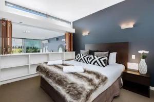 a large bedroom with a large bed and a window at Luxury Lake View - 1 Bedroom in Queenstown