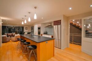 a kitchen and living room with a counter and stools at Mataraki Magic in Wanaka