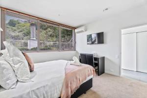 1 dormitorio con cama y ventana grande en Tranquil Modern Studio, en Queenstown