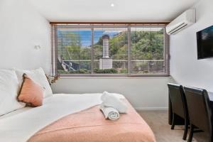a bedroom with a bed and a large window at Tranquil Modern Studio in Queenstown