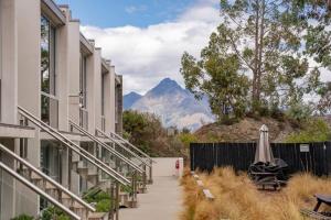 a walkway between buildings with a mountain in the background at Tranquil Modern Studio in Queenstown