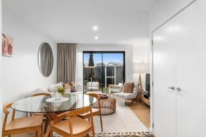 a living room with a glass table and chairs at Wanaka Riverside Townhouse Retreat in Albert Town