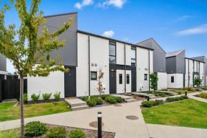 a large white building with a courtyard at Wanaka Riverside Townhouse Retreat in Albert Town