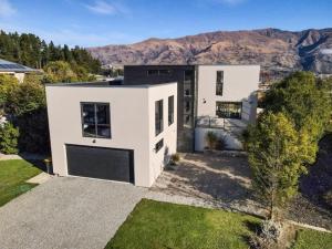 a white house with a mountain in the background at Mataraki Magic in Wanaka