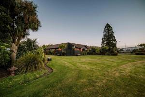 ein großer Hof mit einem Haus und einem Baum in der Unterkunft Entertainers Dream in Christchurch