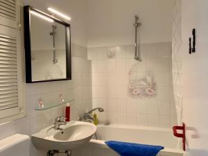 ein weißes Badezimmer mit einem Waschbecken und einer Badewanne in der Unterkunft Home Wilma in Berlin