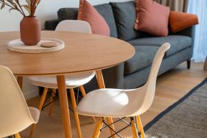 a table and chairs in a living room with a couch at Albert Town Whare in Albert Town