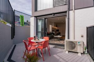 a patio with red chairs and a table on a balcony at Maude View in Albert Town