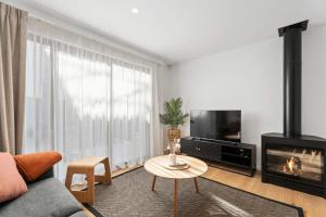 a living room with a couch and a fireplace at Albert Town Whare in Albert Town +13 photos