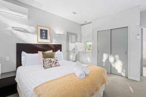 a bedroom with a large bed with white sheets and pillows at Alpine Retreat Studio in Queenstown