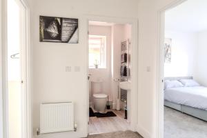 a white bedroom with a bed and a bathroom at BRAND NEW 3 BEDROOM HOUSE WITH GARDEN AND FREE PARKING in Wednesbury