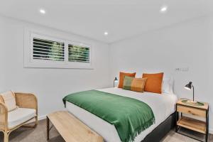 a bedroom with a bed and a chair and a window at Lakeview Luxury Vista in Wanaka +18 photos
