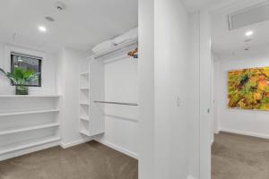 a white hallway with white shelves and a painting at Lakeview Luxury Vista in Wanaka