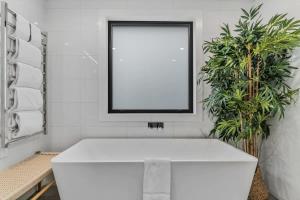 a white sink in a bathroom with two plants at Lakeview Luxury Vista in Wanaka