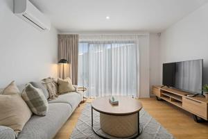 a living room with a couch and a tv at Alps and Lake Retreat Wanaka in Albert Town