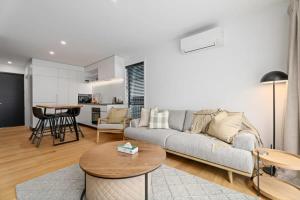 a living room with a couch and a table at Alps and Lake Retreat Wanaka in Albert Town