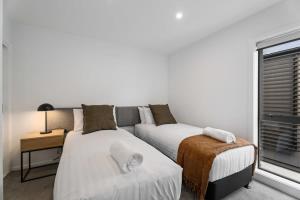 1 dormitorio con 2 camas y ventana en Alps and Lake Retreat Wanaka, en Albert Town