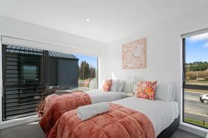 two beds in a bedroom with a large window at Alpine Grandview in Albert Town