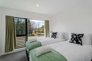 two beds in a room with a window at Riverside Terrace in Albert Town