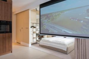 um grande ecrã de projecção num quarto com uma cama em Natura Luxury Apartments II em Iława