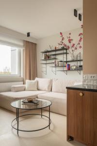 a living room with a white couch and a glass table at Natura Luxury Apartments II in Iława