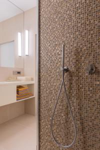 a bathroom with a shower with a tile wall at Natura Luxury Apartments II in Iława