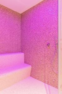a pink bathroom with a shower and a staircase at Natura Luxury Apartments II in Iława