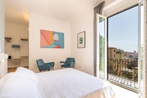a bedroom with a bed and a large window at Le camere sui colli in La Spezia