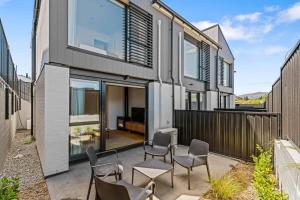 a house with glass doors and chairs on a patio at Rivers Abode in Albert Town +4 photos