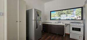 a kitchen with a stainless steel refrigerator and a window at Casa del Rio in Lago Meliquina