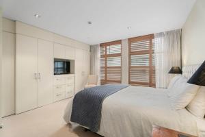 瓦纳卡Luxury Lakeview on Ardmore with Sauna的一间带床和电视的白色卧室