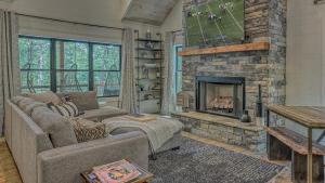 a living room with a couch and a stone fireplace at Holiday House in Blue Ridge