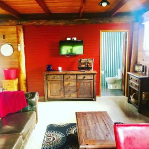 米爾索普的住宿－The Shack Gorgeous Getaway for 2 on Truffle Farm，一间客厅,在红色的墙上配有电视