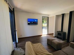 維亞梅立奎納的住宿－Casa del Rio，客厅配有沙发和墙上的电视