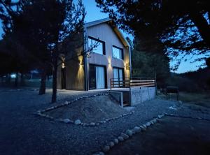 a small house is lit up at night at Casa del Rio in Lago Meliquina