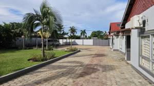 a driveway of a house with a palm tree at Artem Apartments - Apartment 1 in Kitwe