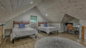 a attic bedroom with two beds and a television at Holiday House in Blue Ridge