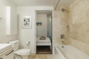 a bathroom with a toilet and a tub and a sink at The One - Make Memories! - Urban City - Boutique in Toronto
